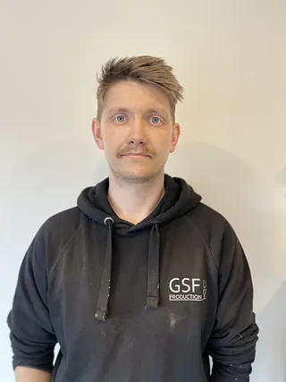 Mann med brunt hår og svart jakke