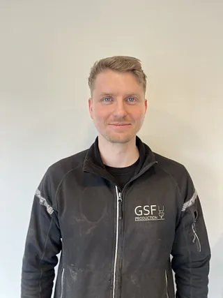 Glad mann med svart jakke og lyst hår