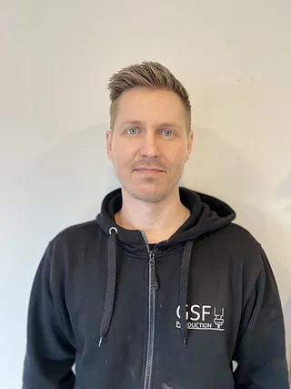 Mann med brunt hår og svart hettejakke