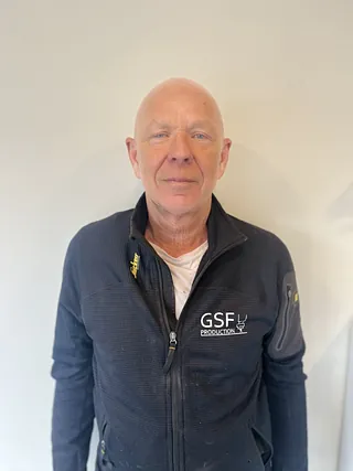 Mann med svart jakke og hvit genser