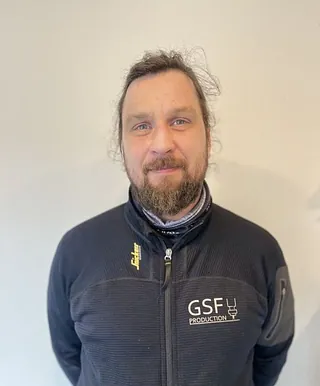 Mann med brunt hår og svart jakke