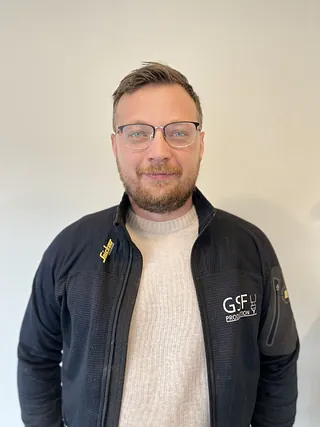 Mann med svart jakke og briller